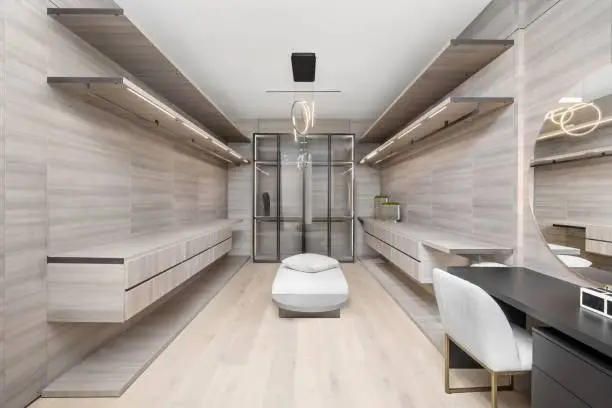 Minimalist custom walk-in closet with handleless cabinetry and warm neutral tones in McLean VA