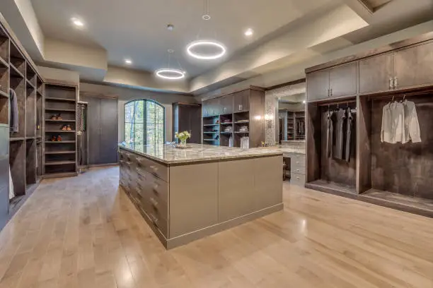 Spacious custom walk-in closet with center island, shoe shelving, and integrated LED lighting in a McLean VA master suite