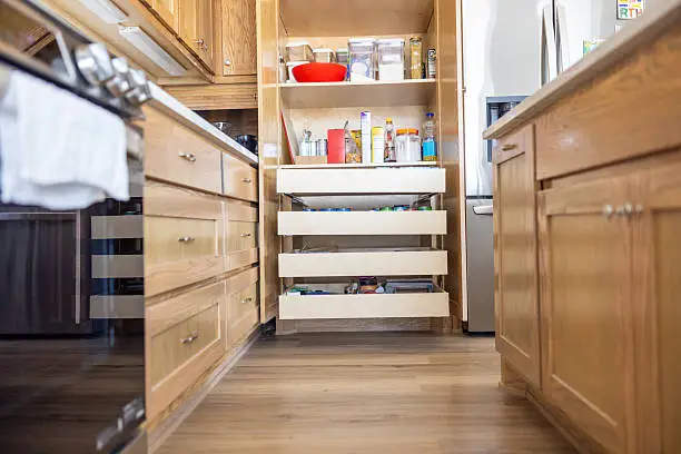Kitchen pantry organization with custom built-in shelving, pull-out drawers, and clear storage containers in a McLean VA home